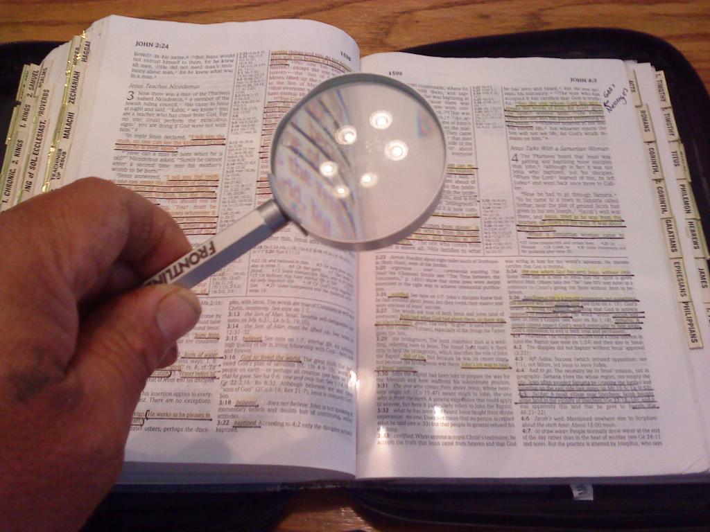 Magnifying glass over an open bible